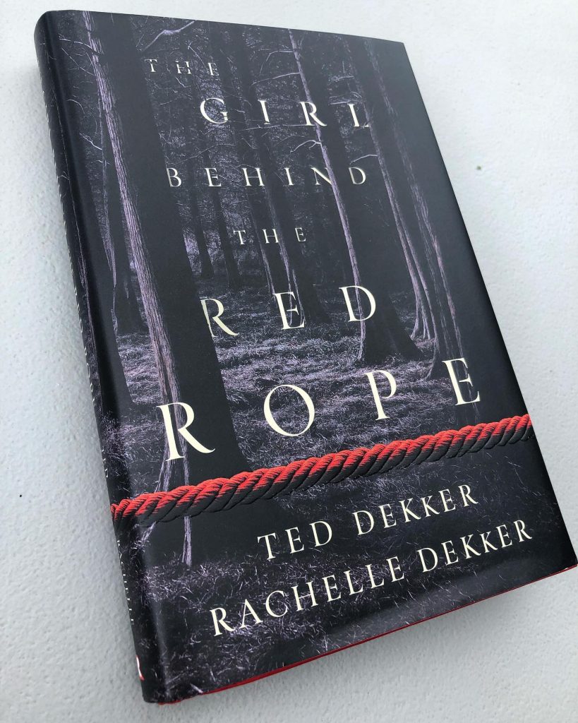 The Girl Behind the Red Rope book cover laying on table